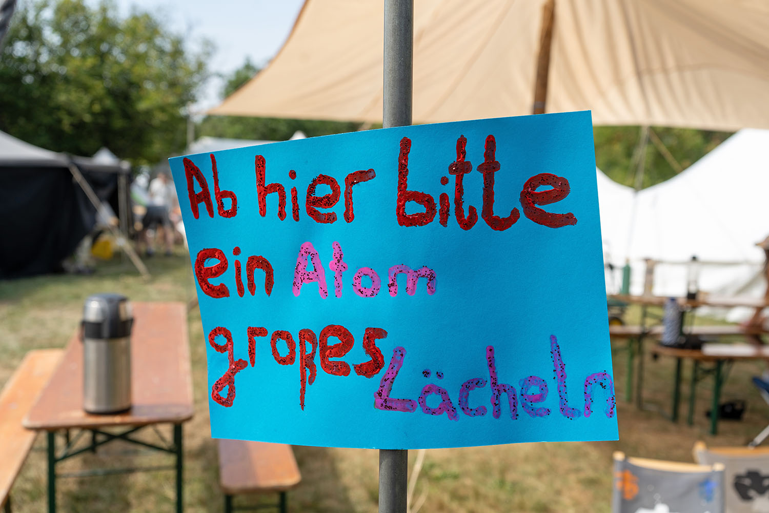 Ein Papierschild mit der Aufschrift «Ab hier bitte ein atomgroßes Lächeln!»